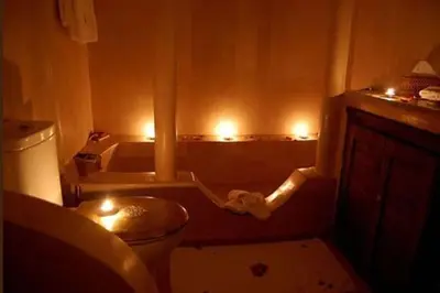 a bathroom with a toilet and a tub with lights at Riad D'Airain in Marrakech
