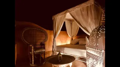 a bedroom with a bed and a chair and a table at The Bohemian Jungle in Marrakech