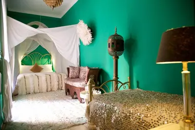 a bedroom with green walls and a bed with a canopy at The Bohemian Jungle in Marrakech