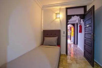 a bed in a room with a door and a hallway at Riad Leila Marrakech in Marrakech