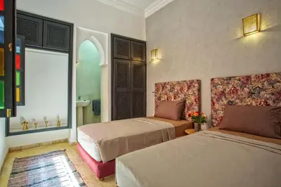 a hotel room with two beds and a window at Riad Leila Marrakech in Marrakech