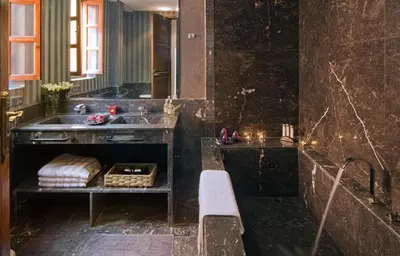a bathroom with a sink and a bench in it at Riad Chayma Marrakech in Marrakech