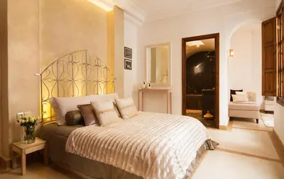 a bedroom with a large bed and a living room at Riad Chayma Marrakech in Marrakech