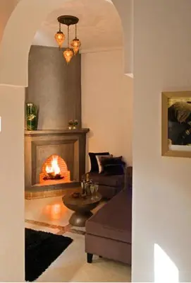 a living room with a fireplace and a couch at Riad Chayma Marrakech in Marrakech