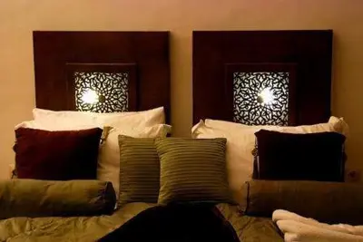 a bed with pillows on it in a room at Riad Chayma Marrakech in Marrakech