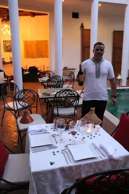 a man standing next to a table in a restaurant at Riad Chergui in Marrakech