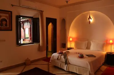 a bedroom with a large white bed and a window at Riad Chergui in Marrakech