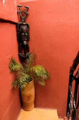 a plant in a pot next to a wall with a mask at Riad Hayed in Marrakech