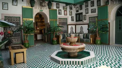 a room with a fountain in the middle of a room at Riad Les Oliviers & Spa in Marrakech