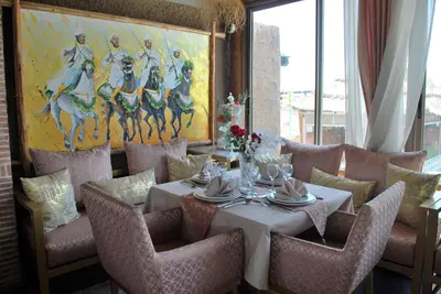 a dining room with a table and chairs and a painting at Riad Les Oliviers & Spa in Marrakech