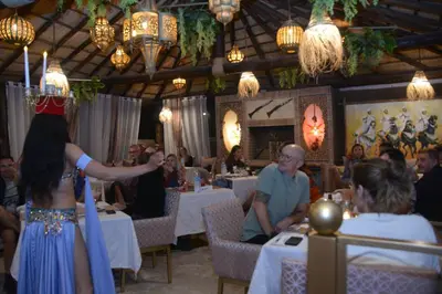 a woman standing in front of a table in a restaurant at Riad Les Oliviers & Spa in Marrakech