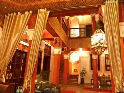 a lobby with columns and a chandelier in a building at Riad Lila in Marrakech