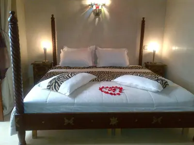 a bedroom with a bed with pillows on it at Riad Lila in Marrakech