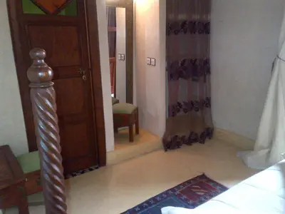 a room with a bed and a mirror and a door at Riad Lila in Marrakech