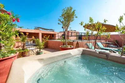 a swimming pool in a backyard with trees and plants at Riad L'orange Bleue in Marrakech