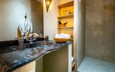 a bathroom with a sink with a suit on a mannequin at Riad L'orange Bleue in Marrakech
