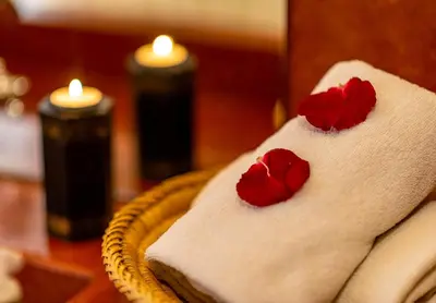 two red roses on a white towel with candles at Riad L'orange Bleue in Marrakech