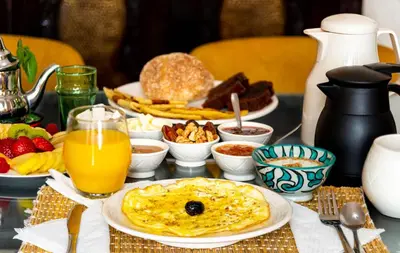 a table topped with breakfast foods and orange juice at Riad L'orange Bleue in Marrakech