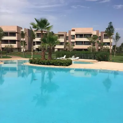 a large blue swimming pool in front of a building at APPARTEMENT Golf Marrakech prestigia in Marrakech