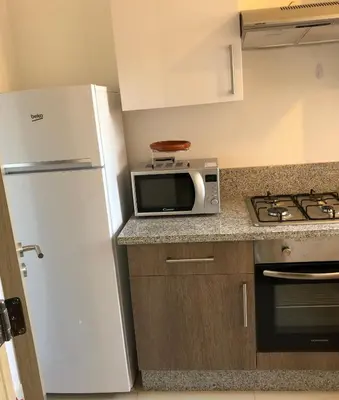 a kitchen with a white refrigerator and a microwave at APPARTEMENT Golf Marrakech prestigia in Marrakech