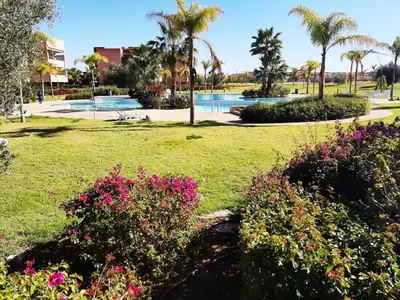 a park with flowers and a swimming pool at APPARTEMENT Golf Marrakech prestigia in Marrakech