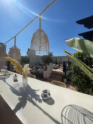 a white table with a vase of flowers on a roof at Riad Jonan & Spa in Marrakech