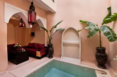 a room with a tub with plants and a couch at Riad Le Rubis in Marrakech