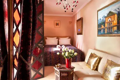 a bedroom with a bed and a couch and a table at Riad Le Rubis in Marrakech
