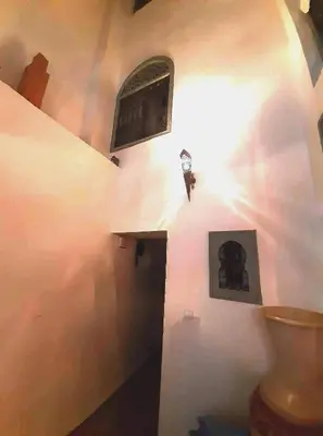 a bathroom with a toilet and a window on the wall at Riad Manaoui in Marrakech