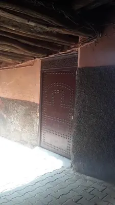 a brown door on the side of a building at Riad Manaoui in Marrakech