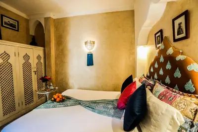a bedroom with a bed with colorful pillows at Riad les 2 Portes in Marrakech