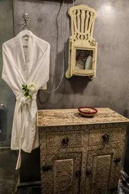 a dressing table with a white robe and a chair at Riad les 2 Portes in Marrakech