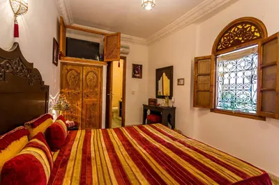 a bedroom with a bed and a window at Riad Mouna in Marrakech