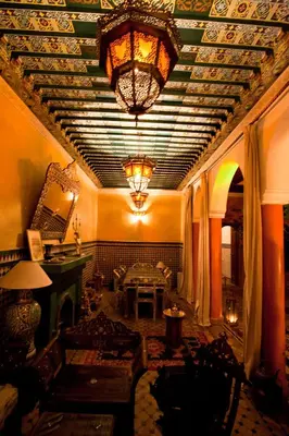 a living room with a ceiling with a chandelier at Riad Lakhdar in Marrakech