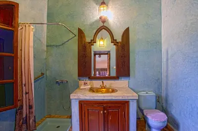 a bathroom with a sink and a toilet and a mirror at Riad Lakhdar in Marrakech