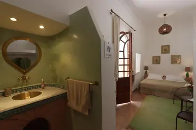 a bathroom with a sink and a bedroom with a bed at Dar Warda in Marrakech