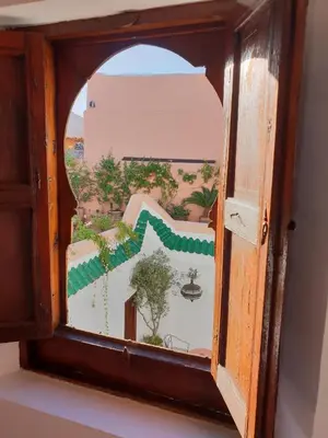 a wooden window with a view of a building at Dar Warda in Marrakech