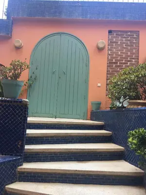 a green door with stairs in front of a building at El Hamra Hotel in Marrakech