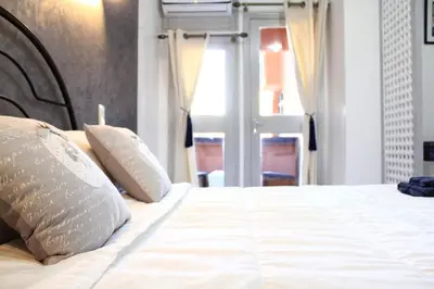 a bed with white sheets and pillows in a bedroom at El Hamra Hotel in Marrakech