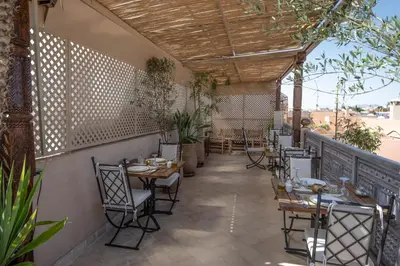 a restaurant with tables and chairs on a patio at Riad Dar Tmania in Marrakech