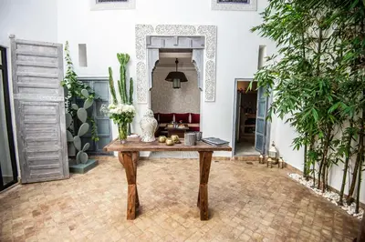 a living room with a table and plants at Riad Dar Tmania in Marrakech