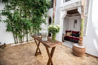 a room with a table with a vase of flowers on it at Riad Dar Tmania in Marrakech
