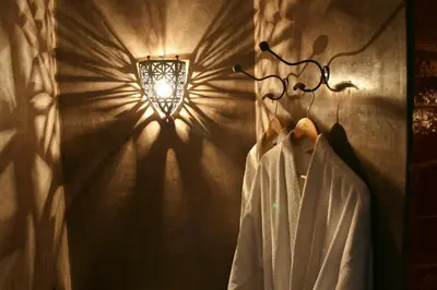 a wall with a light fixture and a robe on a rack at Riad Golfame in Marrakech