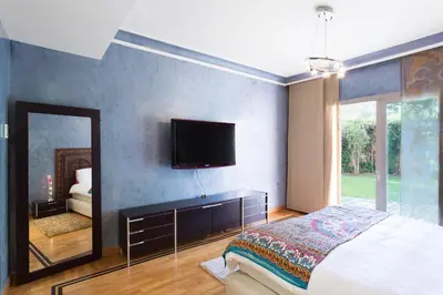 a bedroom with a bed and a mirror and a tv at The Ruby Apartment with Private Swimming Pool - Hivernage Quarter - By Goldex Marrakech in Marrakech