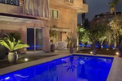 a swimming pool in front of a house at night at The Ruby Apartment with Private Swimming Pool - Hivernage Quarter - By Goldex Marrakech in Marrakech