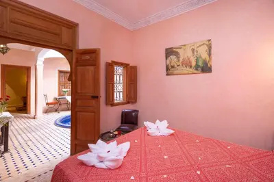 a bedroom with a bed with flowers on it at Riad Arbre Bleu in Marrakech