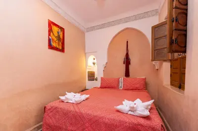 a bedroom with a red bed with white flowers on it at Riad Arbre Bleu in Marrakech