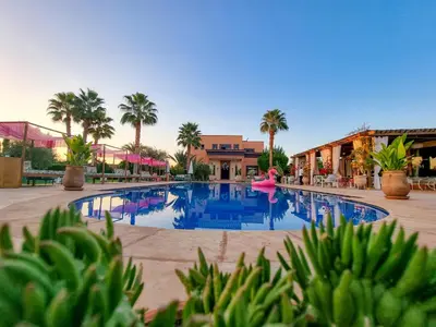 a swimming pool with a pink float in the middle at La Villa Des Golfs & PinkCactus in Marrakech