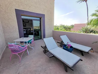 a patio with two tables and chairs and a table at La Villa Des Golfs & PinkCactus in Marrakech