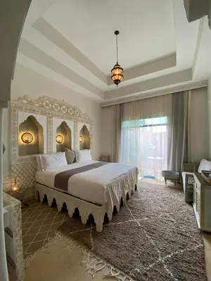 a bedroom with a large bed and a large window at La Villa Des Golfs & PinkCactus in Marrakech